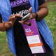 New Georgia Project canvasser Mardie Hill holds informational door hangers about the upcoming primary election on May 23, 2022, in East Point, Georgia.